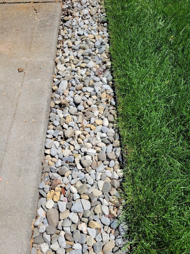 Ez-flow drainage along drive edge with stone.